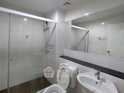 Modern bathroom with glass shower and sleek fixtures in a contemporary home.
