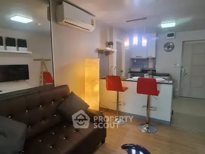 Modern living room with open kitchen, stylish decor, and cozy ambiance.