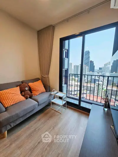 Modern living room with city view, cozy sofa, and large window in urban apartment.