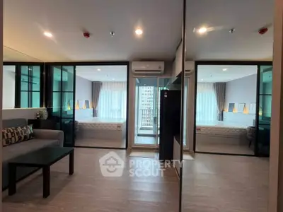 Modern apartment interior with mirrored walls and balcony view, featuring sleek design and natural light.