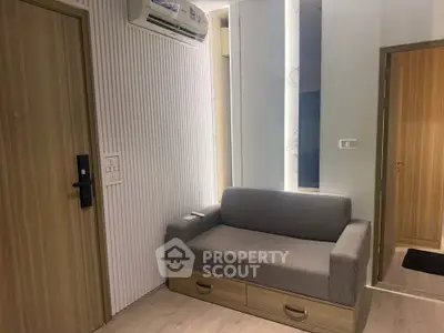 Modern apartment interior with sleek sofa and stylish wooden door, perfect for urban living.