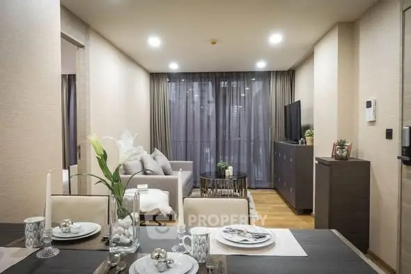 Modern living room with elegant decor and open dining area, featuring stylish furniture and ambient lighting.