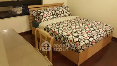 Cozy bedroom with stylish bedding and wooden furniture, perfect for relaxation.