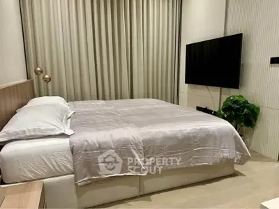Modern bedroom with sleek design and wall-mounted TV