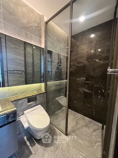 Luxurious modern bathroom with sleek marble tiles and glass shower enclosure