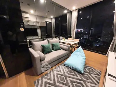 Modern living room with city view, stylish decor, and cozy seating area.