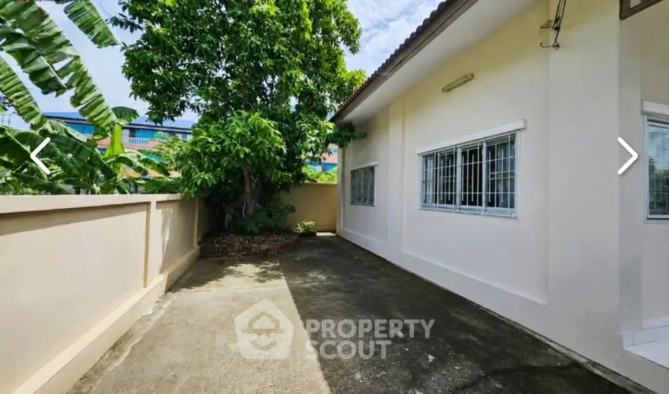 Charming exterior view of a single-story home with lush greenery and spacious driveway.