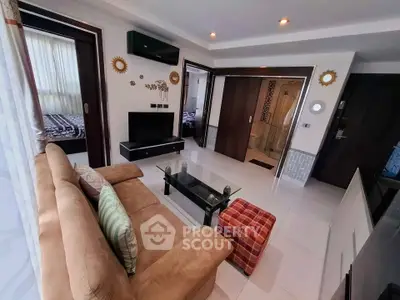 Modern living room with cozy sofa, glass coffee table, and stylish decor in a well-lit apartment.