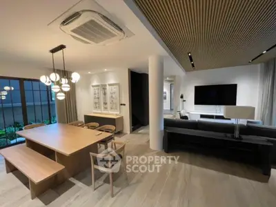 Modern open-plan living and dining area with stylish lighting and wooden accents.