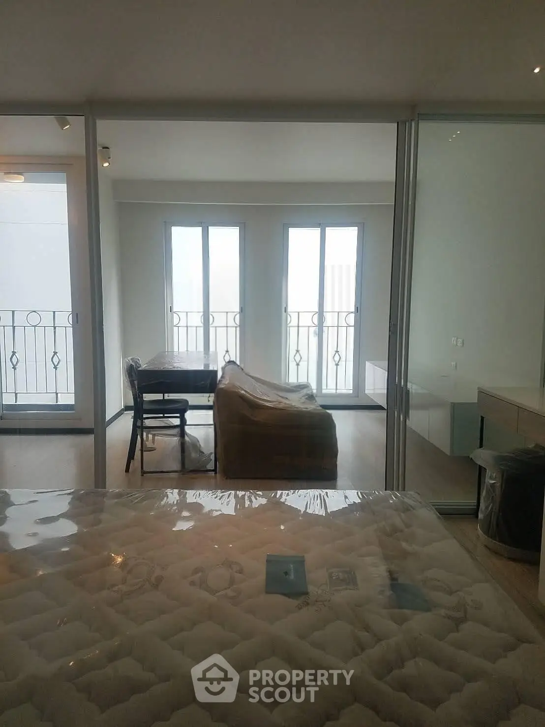 Modern apartment interior with cozy living room and balcony view, featuring stylish furniture and natural light.