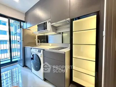 Modern kitchen with sleek appliances and washing machine in a stylish apartment.