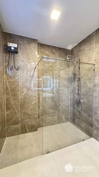 Luxurious modern bathroom with elegant glass shower enclosure and marble tiles