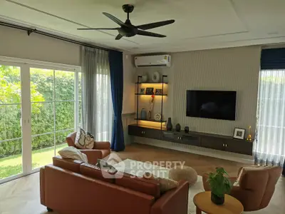 Elegant living room with modern decor, large windows, and garden view