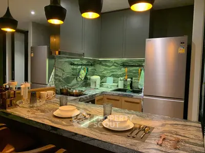 Modern kitchen with sleek design, featuring stainless steel appliances and elegant lighting.