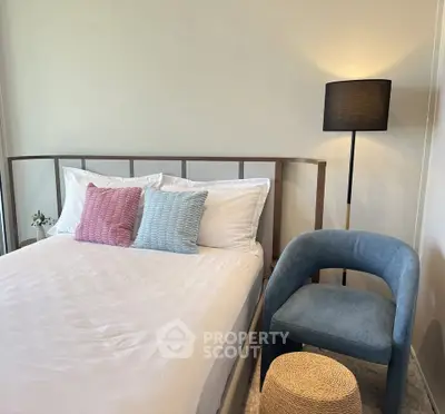 Cozy bedroom with modern decor, featuring a stylish bed, elegant chair, and ambient lighting.