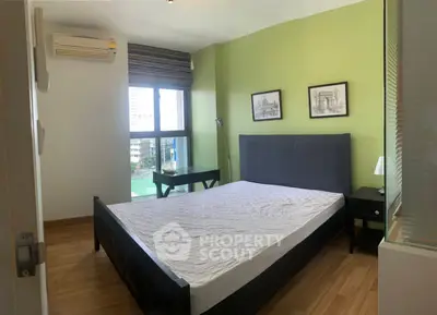 Modern bedroom with green accent wall and large window view