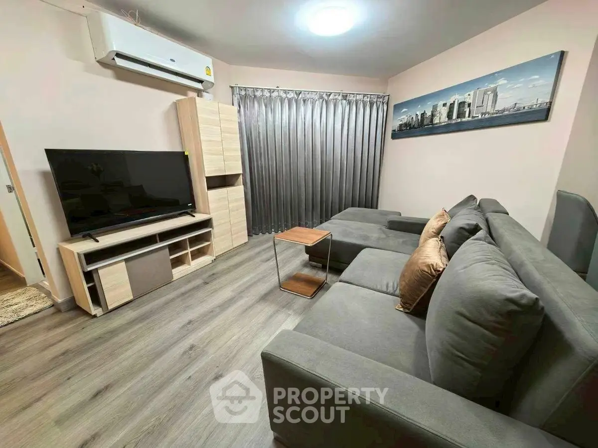 Modern living room with sleek furniture and large TV, perfect for relaxation and entertainment.