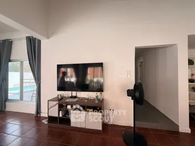 Spacious living room with pool view and modern entertainment setup