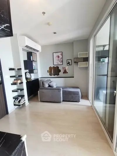 Modern living room with stylish decor and glass partition in a cozy apartment.