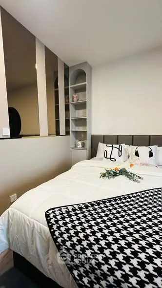 Cozy bedroom with modern decor and built-in shelving, perfect for relaxation and comfort.