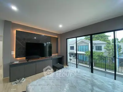 Modern bedroom with large TV and balcony view in stylish home