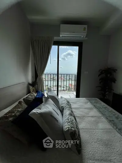 Cozy bedroom with balcony offering stunning city view and modern air conditioning.