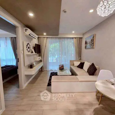 Modern living room with elegant decor and open layout, featuring a cozy sofa and stylish lighting.