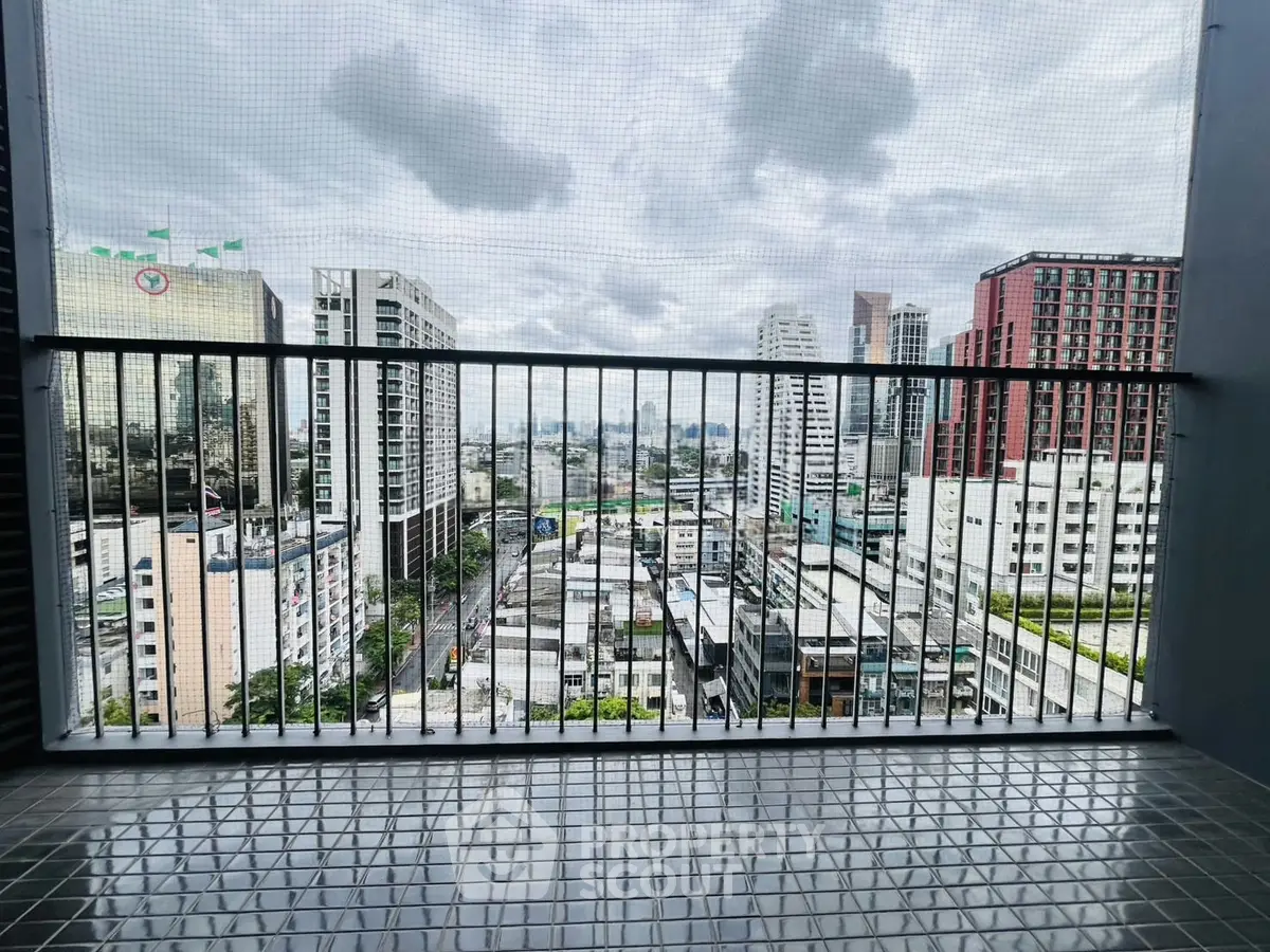 Stunning cityscape view from a high-rise balcony with sleek railing and urban skyline.