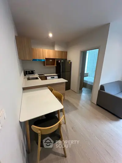 Modern kitchen with sleek design and open layout, featuring wooden cabinets and dining area.