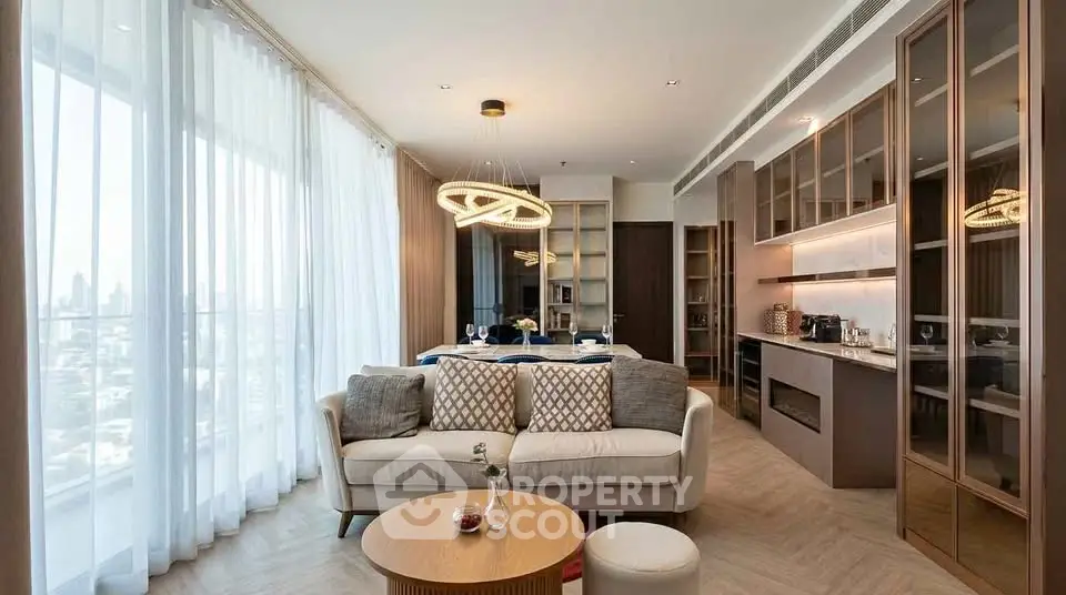 Luxurious modern living room with open kitchen and elegant decor in high-rise apartment.