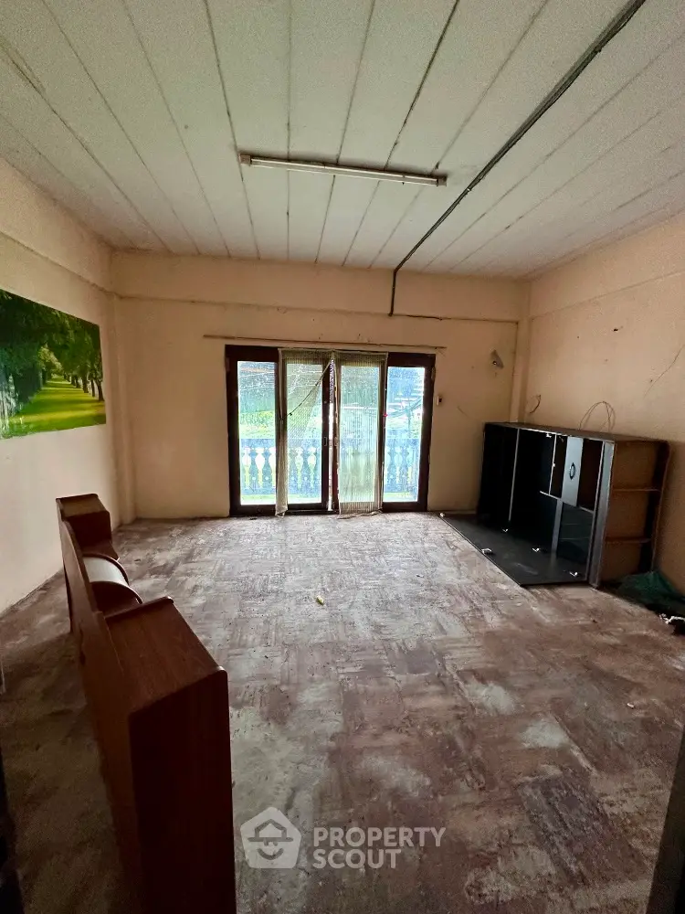 Spacious empty room with large windows and balcony access, ideal for customization.