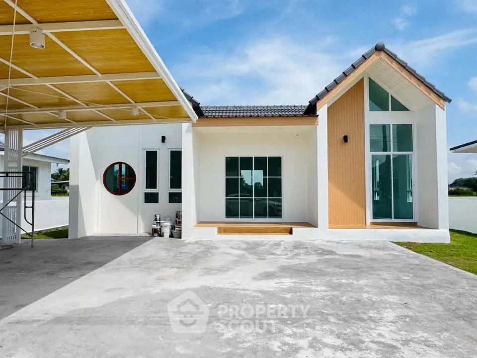 Modern minimalist house exterior with large windows and unique architectural design.