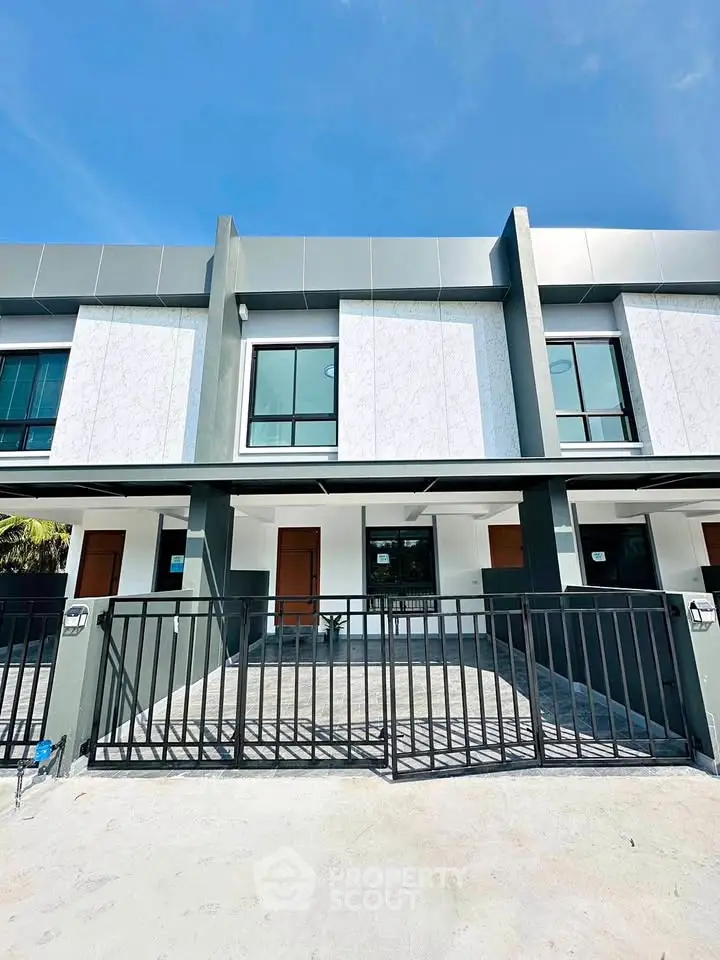 Modern townhouse exterior with sleek design and gated front yard