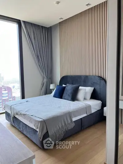 Modern bedroom with stylish decor and large window offering city view