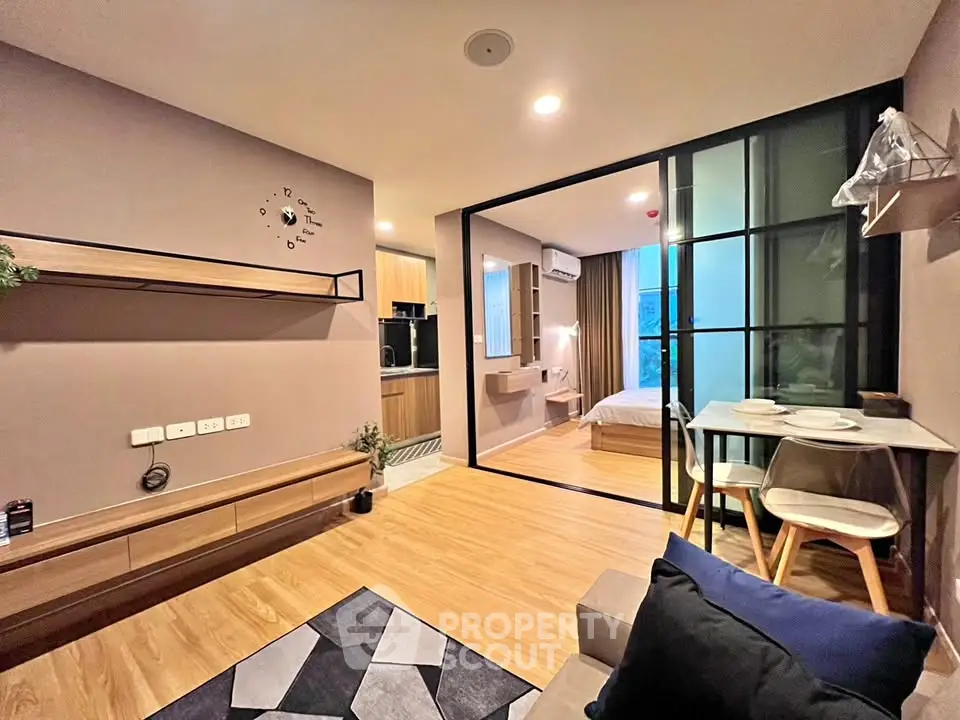 Modern open-plan living room with stylish decor and cozy bedroom view