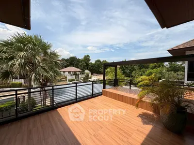 Spacious balcony with stunning view of lush greenery and serene waterway, perfect for relaxation.