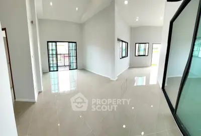 Spacious modern living room with glossy tiled floors and large windows