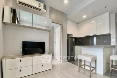Modern living room with sleek kitchen and stylish furniture in a compact apartment.