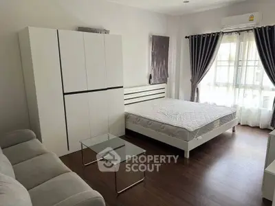 Spacious bedroom with modern furniture and natural light