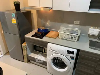 Modern kitchen with washing machine and sleek appliances in compact layout
