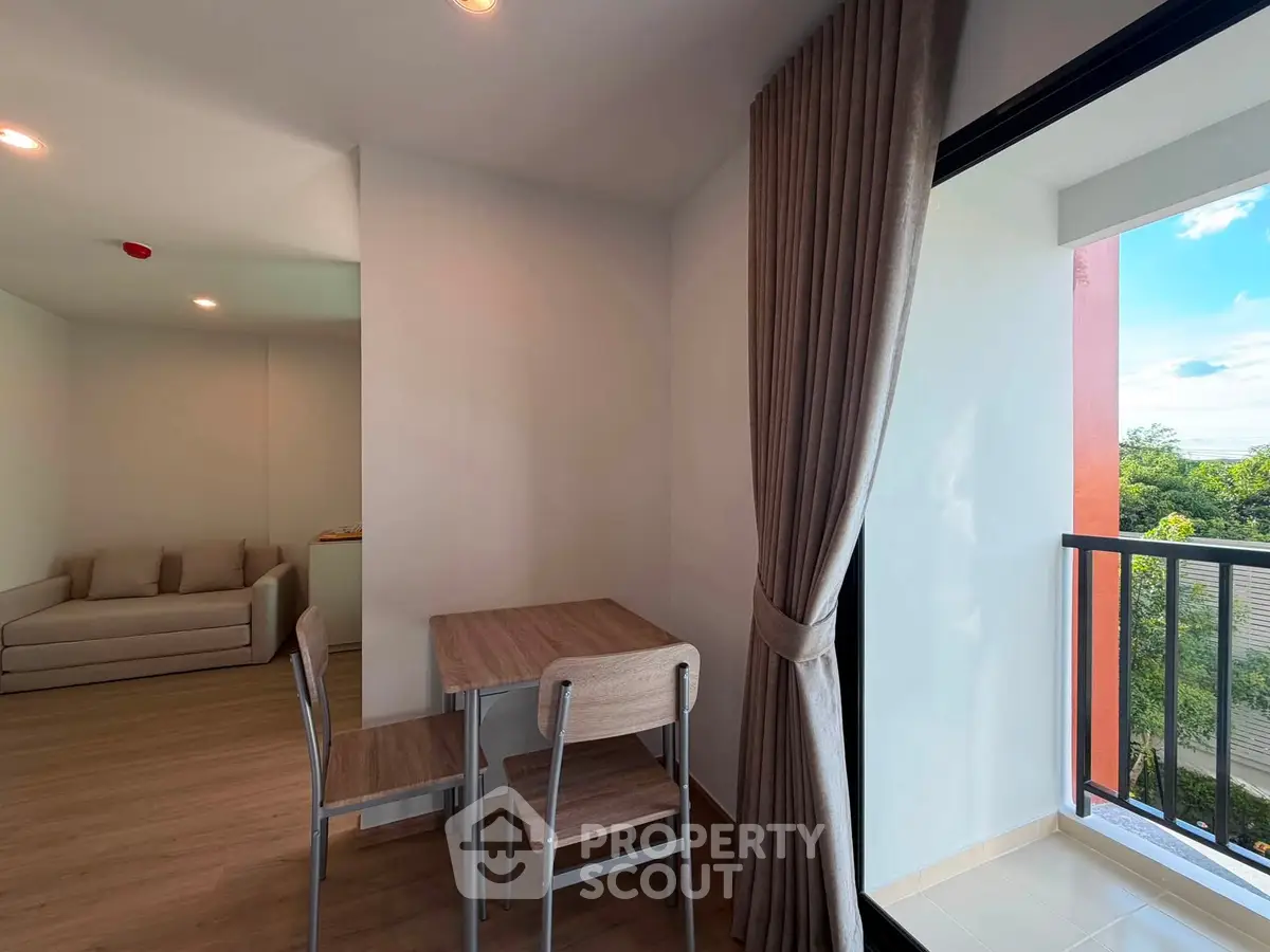 Modern apartment with open living area and balcony view, featuring stylish furniture and natural light.