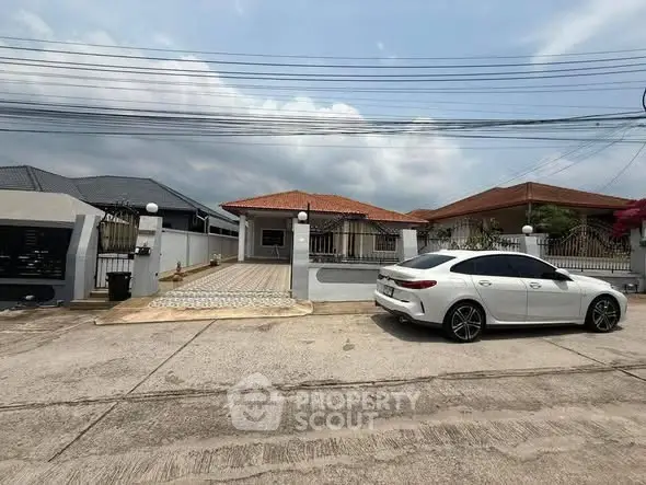 Charming single-story home with spacious driveway and modern car parked outside.