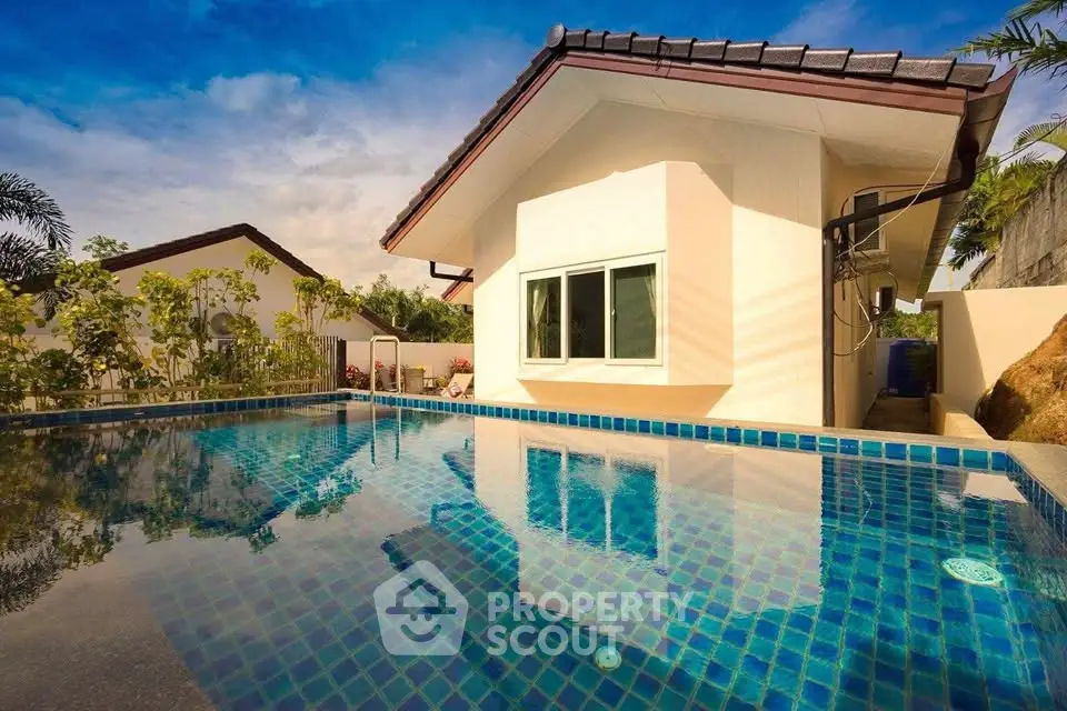 Stunning modern home with a luxurious pool reflecting the clear blue sky, perfect for relaxation and entertainment.