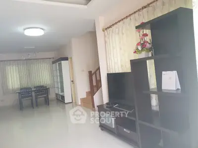 Spacious living room with modern furniture and dining area, ideal for family gatherings.