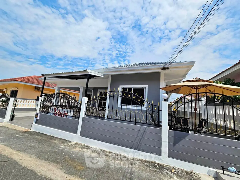 Charming single-story house with fenced yard and patio under a clear blue sky.