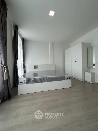 Spacious modern bedroom with minimalist design and ample natural light