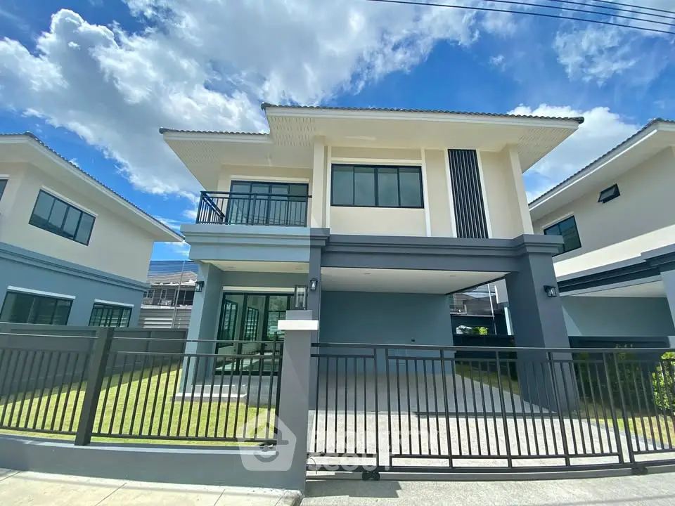 Modern two-story house with spacious driveway and lush green lawn under a clear blue sky.