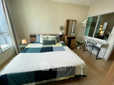 Modern bedroom with stylish decor and large window offering natural light.