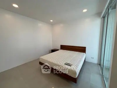 Spacious minimalist bedroom with large bed and natural light