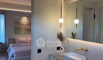 Modern bedroom with stylish bathroom, featuring elegant lighting and contemporary decor.